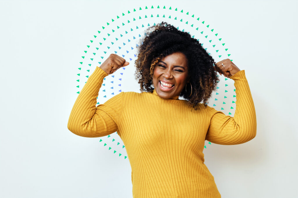 Woman flexing for strength and smiling confidently