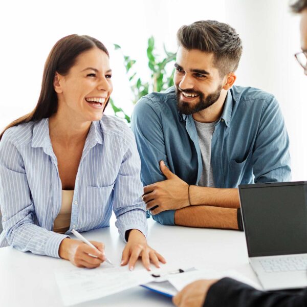 Real estate agent with couple shaking hands closing a deal