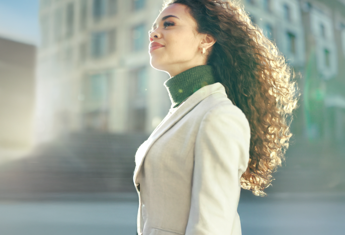 Woman smiling in business suit while walking to work