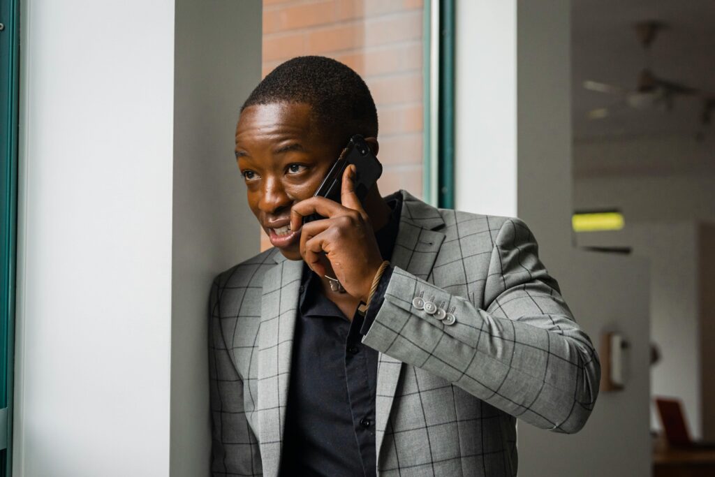 man in suit jacket while talking on cell phone